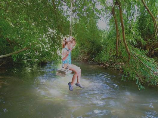 ילדה מתנדנדת במים. עין אביאל