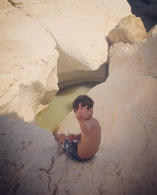 ילד יושב על הסלעים, שמורת עין ירקעם