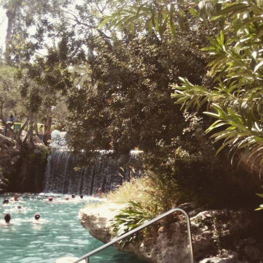 מפל מים ואנשים בתוך בריכת מים בסחנה- גן לאומי גן השלושה