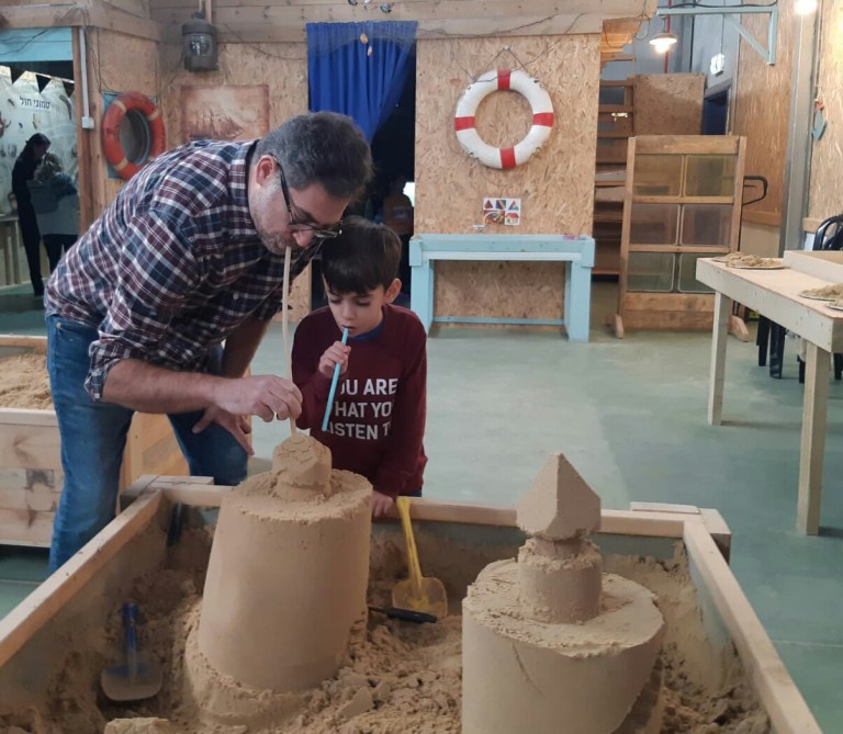 תום ודותן מפסלים בחול. החול יכול